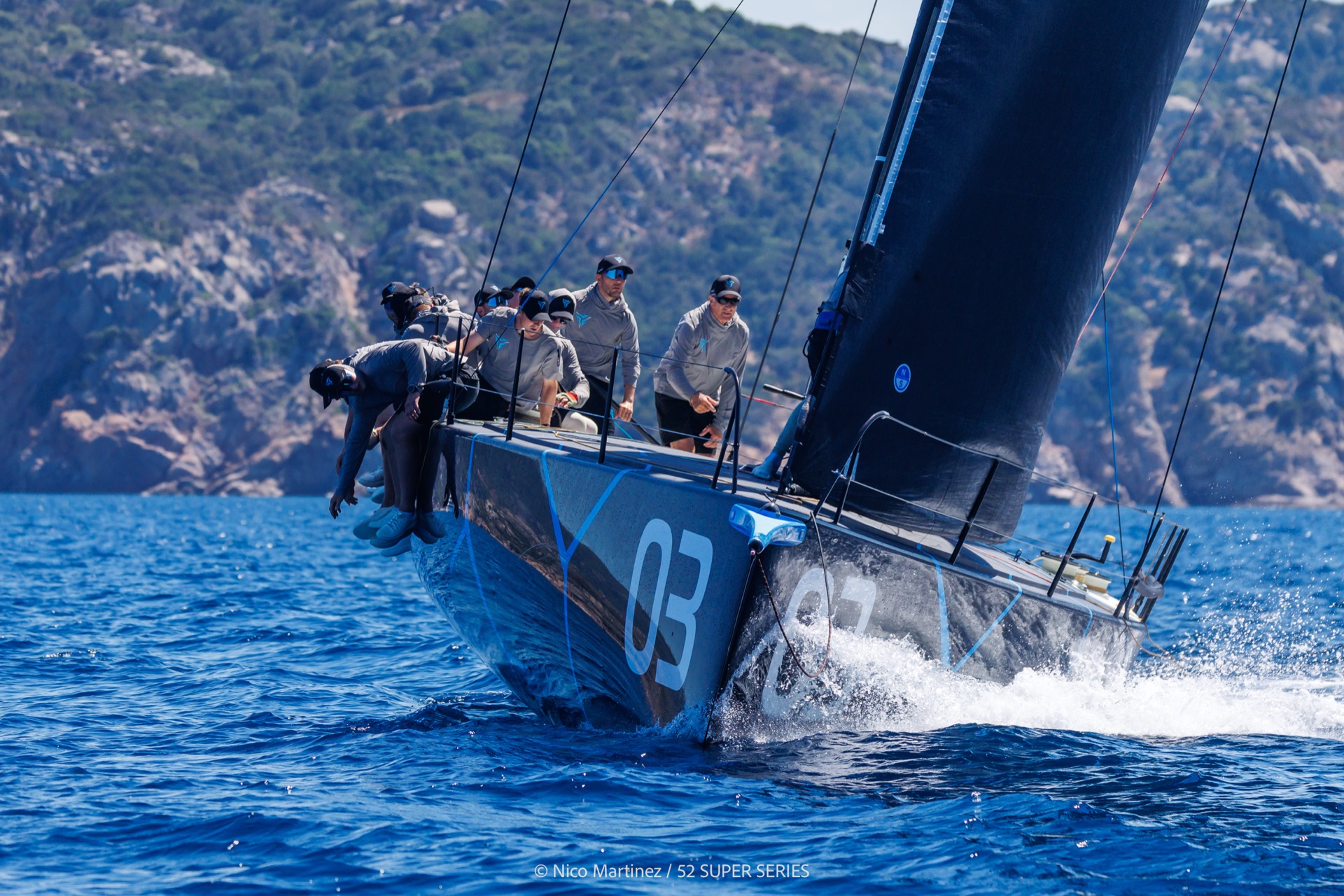 The Nordic Stars TP52 sailing upwind at speed, crew hiked out on the rail, bow wave breaking