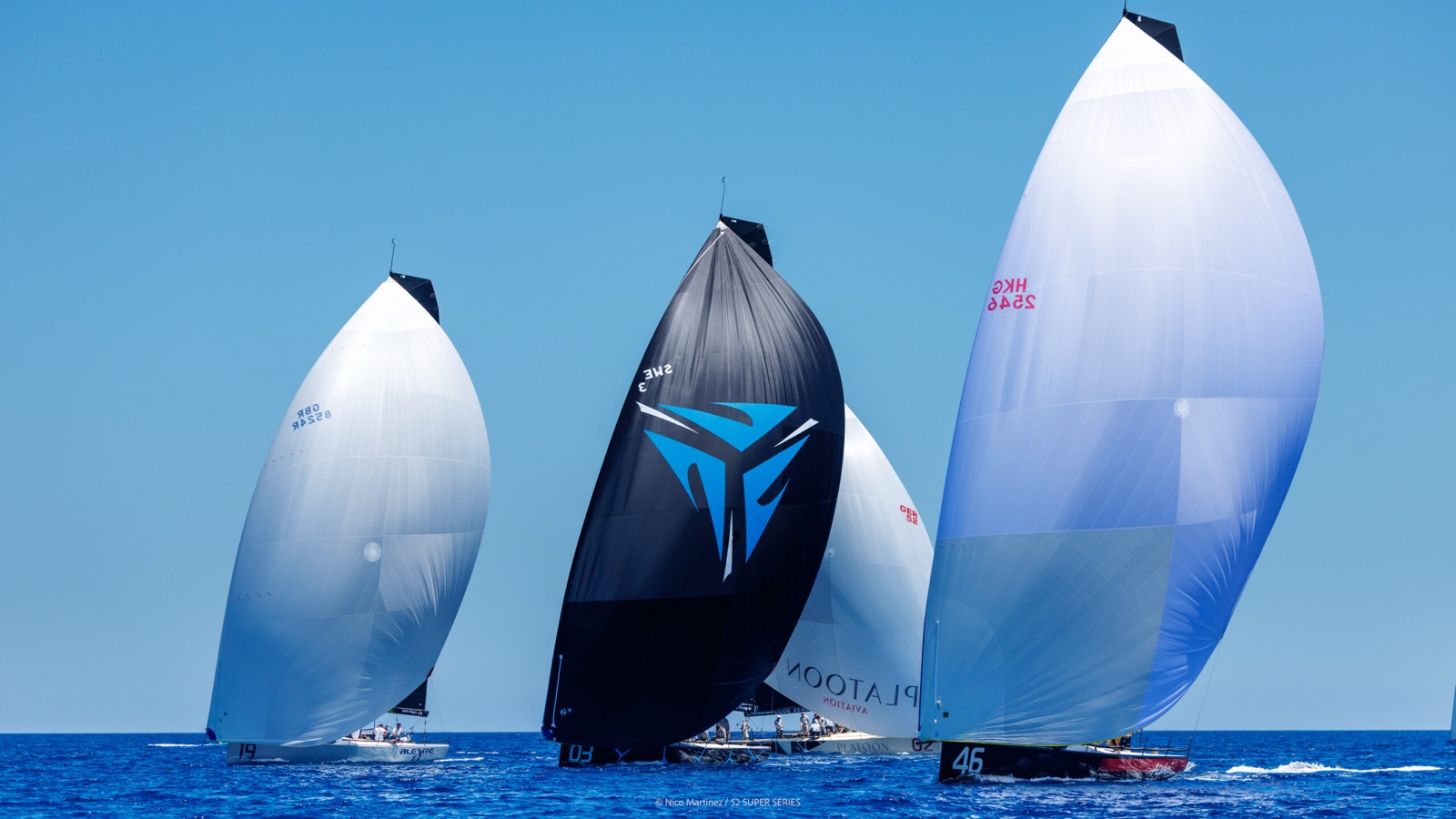 Three TP52s running downwind under spinnaker, Nordic Stars in black in the middle